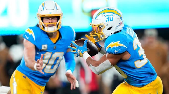 Chargers quarterback Justin Herbert tosses the ball to Austin Ekeler